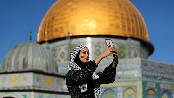 Палестинка снимает селфи на фоне Купола Скалы во время молитвы Ид-аль-Фитр, в Старом городе Иерусалима - Sputnik Тоҷикистон