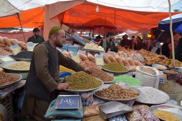 Продавец ждет покупателей у своего ларька с сухофруктами и печеньем в преддверии праздника - Sputnik Таджикистан