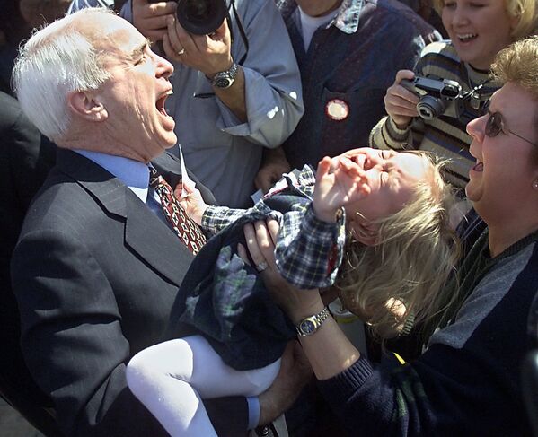 Американский политик Джон МакКейн с маленькой девочкой на руках в Южной Каролине, 2000 год  - Sputnik Тоҷикистон