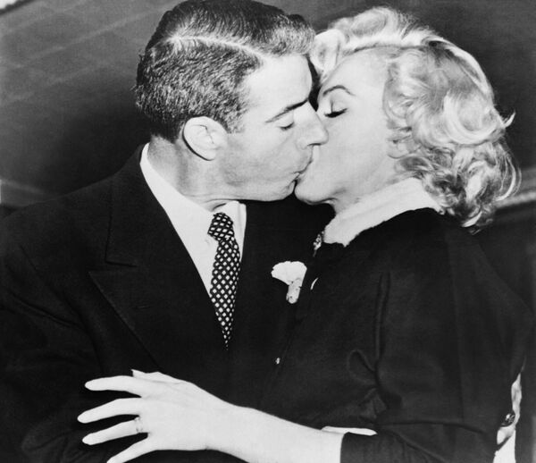 Актриса Мэрилин Монро целует своего второго мужа - знаменитого бейсболиста Джо Ди Маджо. - Sputnik Таджикистан