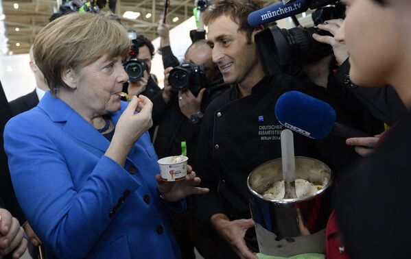 Канцлер Германии Ангела Меркель пробует мороженое, которое для нее сделал чемпион ФРГ по мороженому - 2014 Адриано Колле на международной выставке Handwerksmesse в Мюнхене, 2015 год - Sputnik Таджикистан