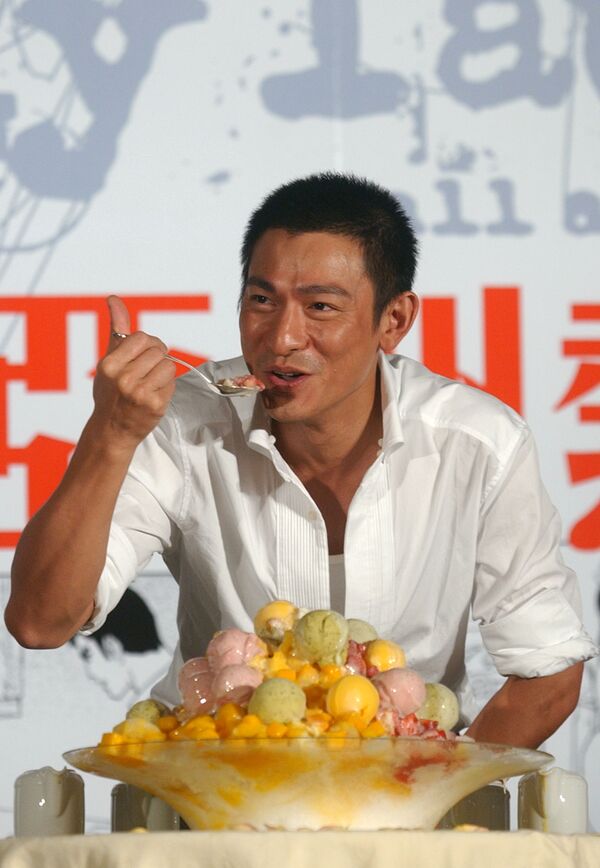 Гонконгский певец и актер Энди Лау пробует мороженое во время фотосессии в Тайбэе, Тайвань, 2005 год - Sputnik Таджикистан