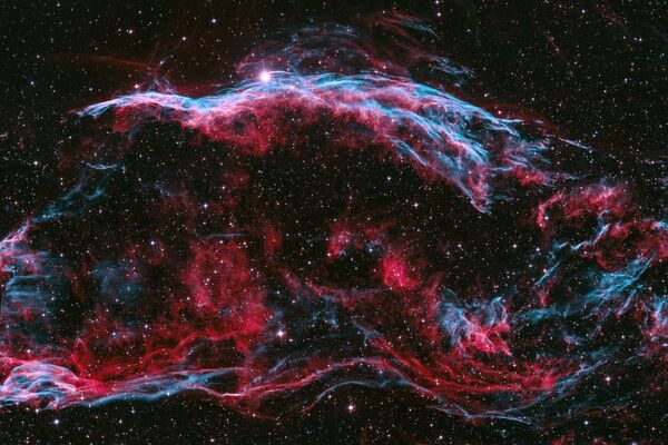 Остатки взорвавшейся сверхновой - двухцветная туманность Вуаль венгерского фотографа Питера Фелтоти. - Sputnik Таджикистан