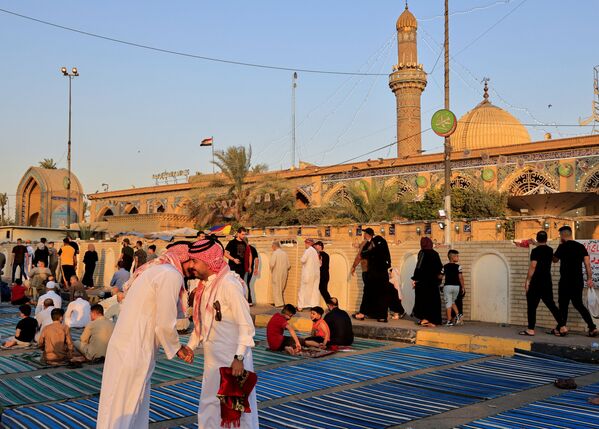 Иракские верующие обмениваются приветствиями после молитвы по случаю Курбан-байрама на улице возле мечети Абу Ханифа. - Sputnik Таджикистан