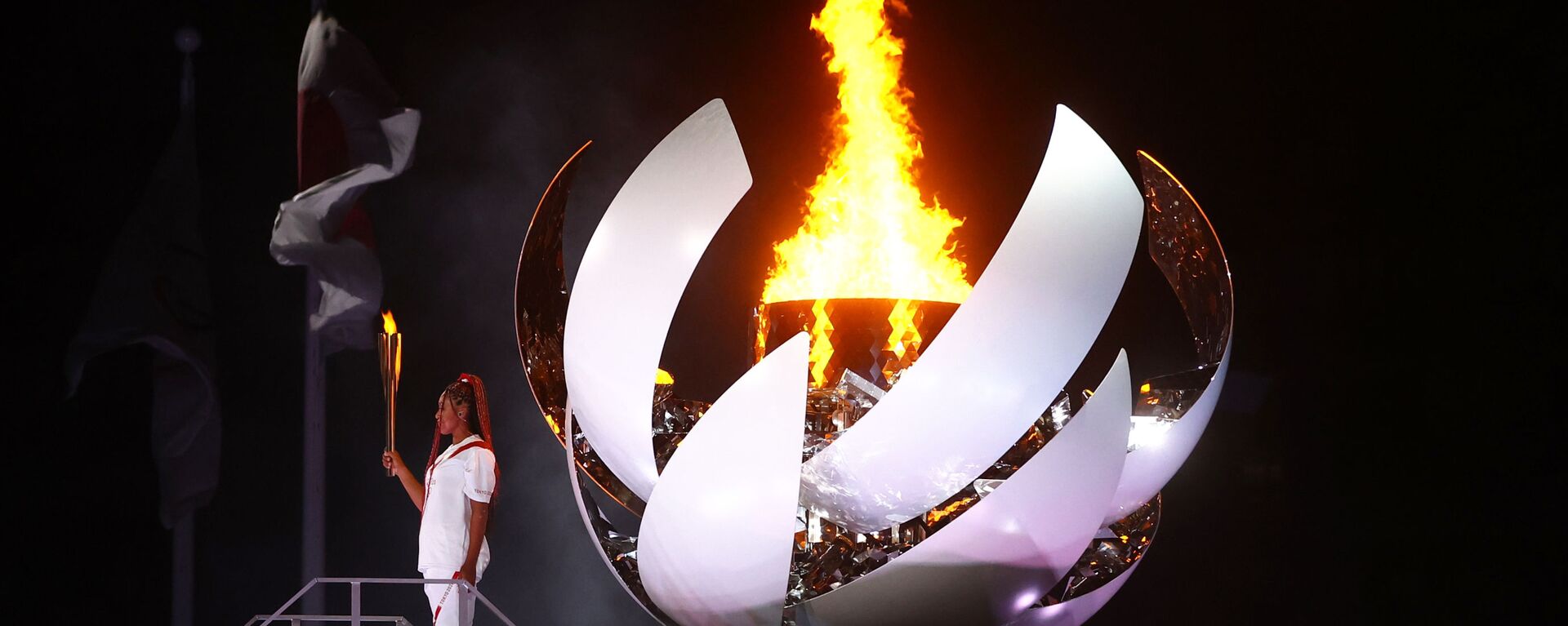 Наоми Осака из Японии держит олимпийский факел после зажжения олимпийского котла на церемонии открытия  - Sputnik Тоҷикистон, 1920, 08.08.2021