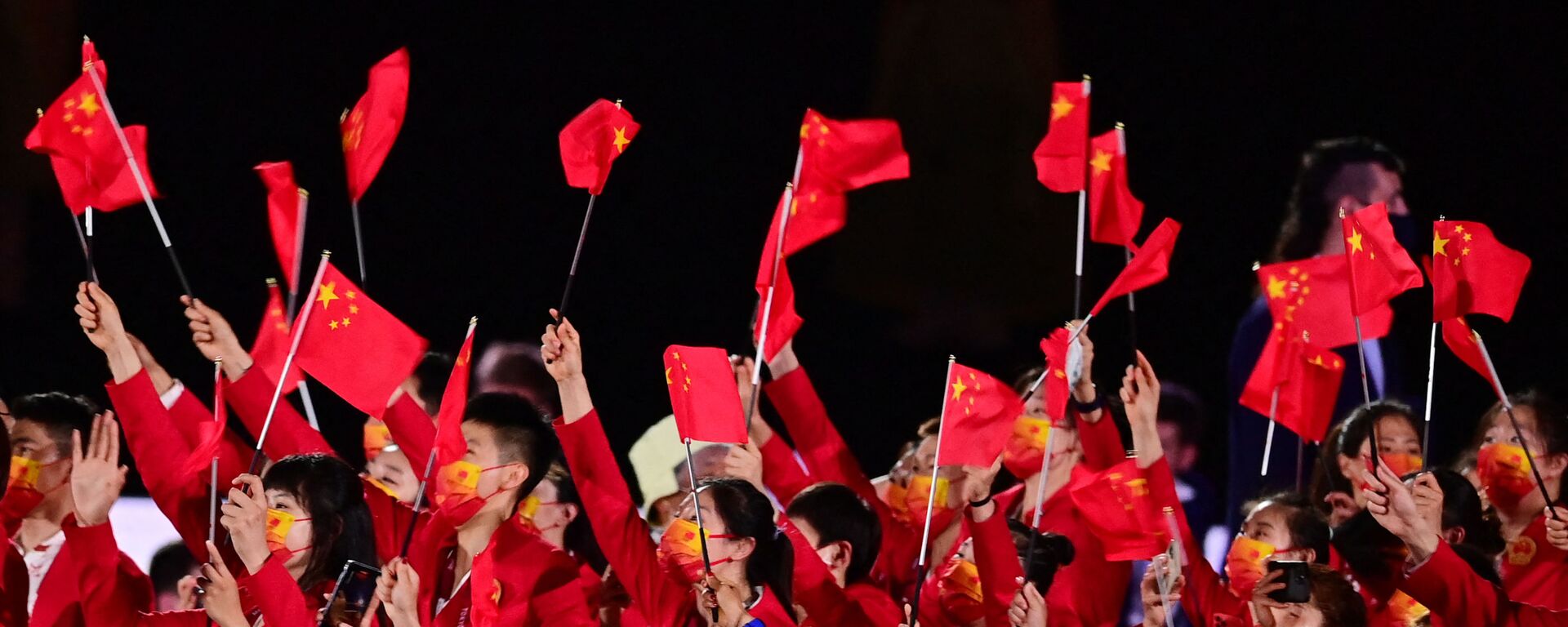 Члены китайской делегации машут флагами, входя на Олимпийский стадион во время церемонии открытия в Токио - Sputnik Таджикистан, 1920, 05.09.2021