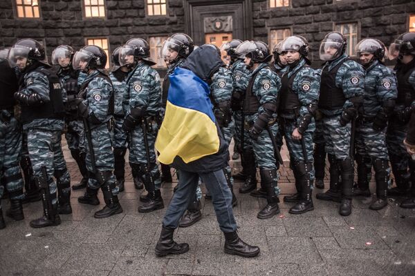 Сторонник евроинтеграции Украины и сотрудники милиции у здания правительства страны в Киеве - Sputnik Таджикистан