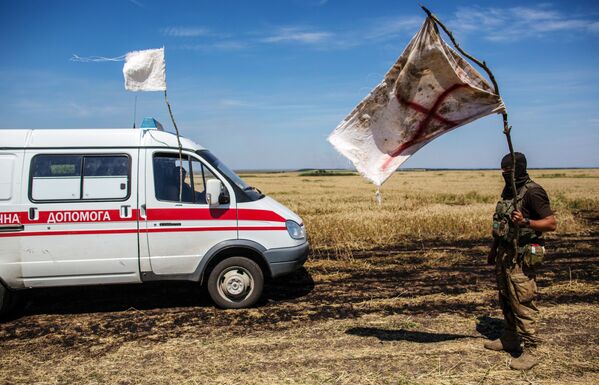 Украинский военный с белым флагом во время передачи убитых на нейтральной территории вблизи поселка Диброво в Донецкой области - Sputnik Таджикистан