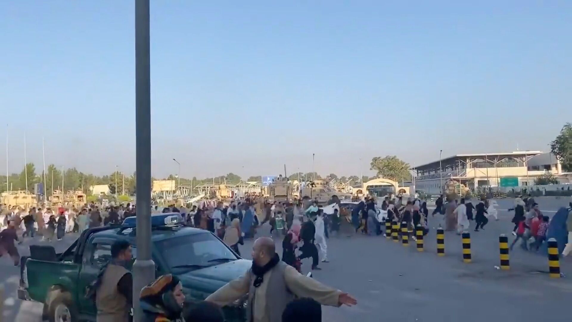 Люди бегут к терминалу Кабульского аэропорта после захвата президентского дворца группировкой Талибан* - Sputnik Тоҷикистон, 1920, 26.12.2021