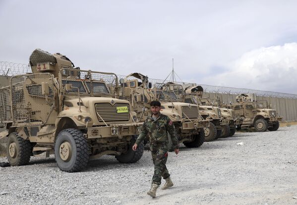 Солдат афганской армии проходит мимо автомобилей с защитой от мин и засад MRAP - Sputnik Таджикистан
