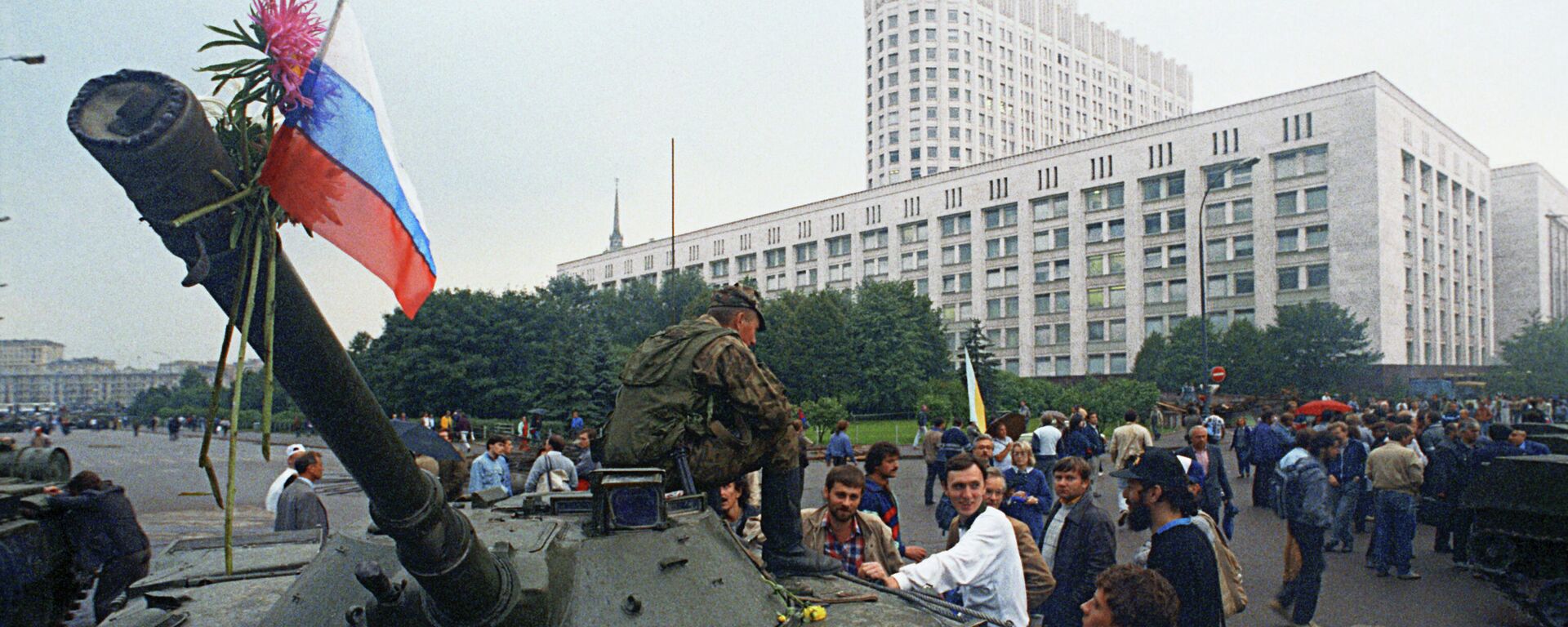 Защитники Белого дома прикрепили цветы к орудийному стволу одного из танков, введеных в Москву 19 августа 1991 года в связи с объявлением членами ГКЧП чрезвычайного положения в столице - Sputnik Таджикистан, 1920, 19.08.2021
