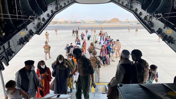 Граждане Испании и афганцы садятся в военный самолет в рамках эвакуации в международном аэропорту Хамида Карзая в Кабуле - Sputnik Тоҷикистон