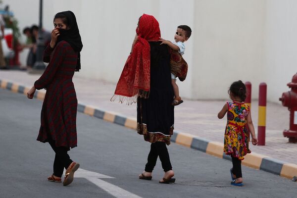 Афганские женщины и дети в жилом комплексе недалеко от центра столицы Катара, где поселились беженцы, недавно прибывшие из Афганистана. - Sputnik Таджикистан