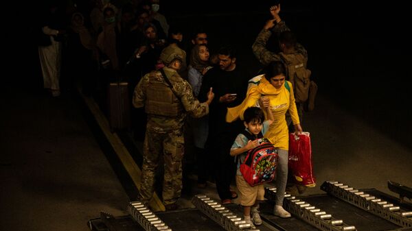 Эвакуированные из Афганистана во время посадки на самолет  - Sputnik Таджикистан