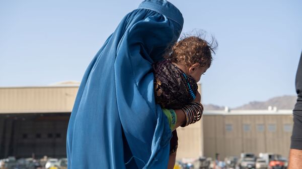 Женщина с ребенком во время эвакуации в Кабуле  - Sputnik Тоҷикистон