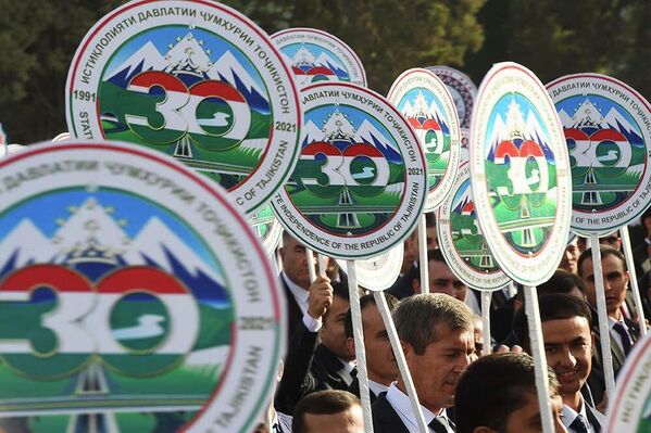Демонстранты также держали в руках другую государственную  символику и новую эмблему 30-летия независимости Таджикистана.  - Sputnik Таджикистан