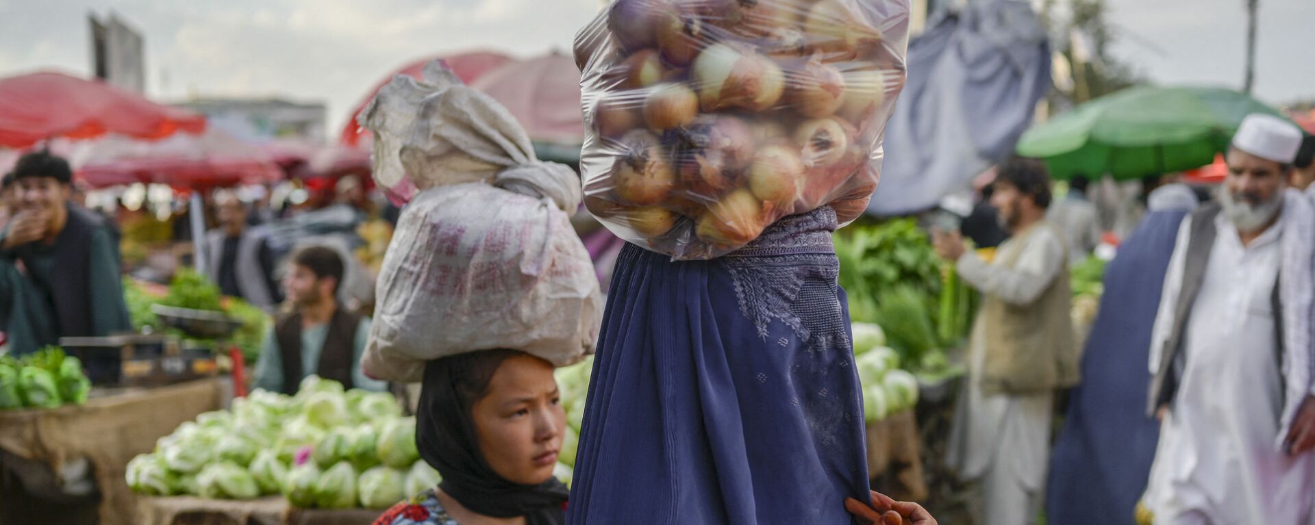 Женщина в парандже несет на голове мешок с луком на рынке в Кабуле - Sputnik Тоҷикистон, 1920, 06.10.2022