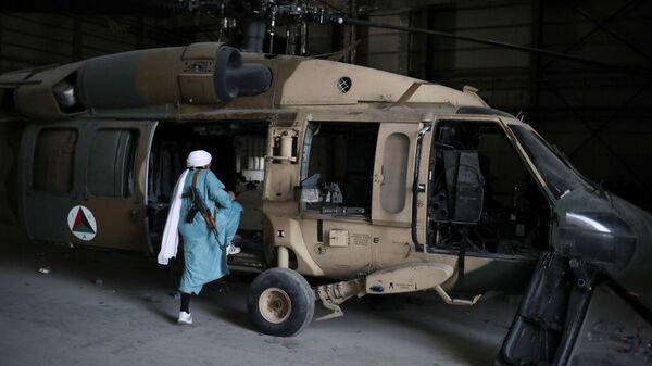 Боец Талибана* садится в вертолет на авиабазе Баграм в Парване, Афганистан - Sputnik Тоҷикистон