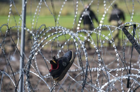 Беженцы сушат вещи и обувь на приграничной колючей проволоке. - Sputnik Таджикистан
