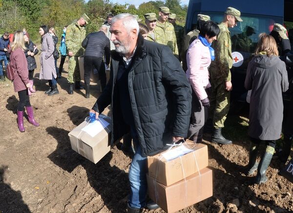 Депутат белорусского парламента Тенгиз Думбадзе несет коробки с гуманитарной помощью для беженцев. - Sputnik Таджикистан