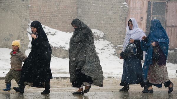 Афганские жители идут по улице во время снегопада в Кабуле, архивное фото - Sputnik Тоҷикистон