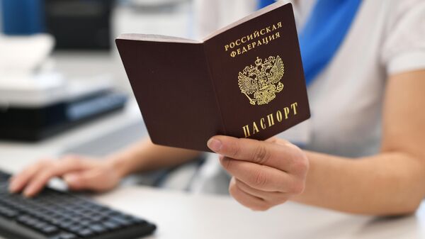Сотрудник ПФР держит в руках паспорт РФ. - Sputnik Тоҷикистон