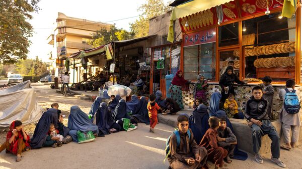 Женщины и дети выстроились в очередь возле пекарни в Кабуле, ожидая раздачи бесплатного хлеба - Sputnik Таджикистан