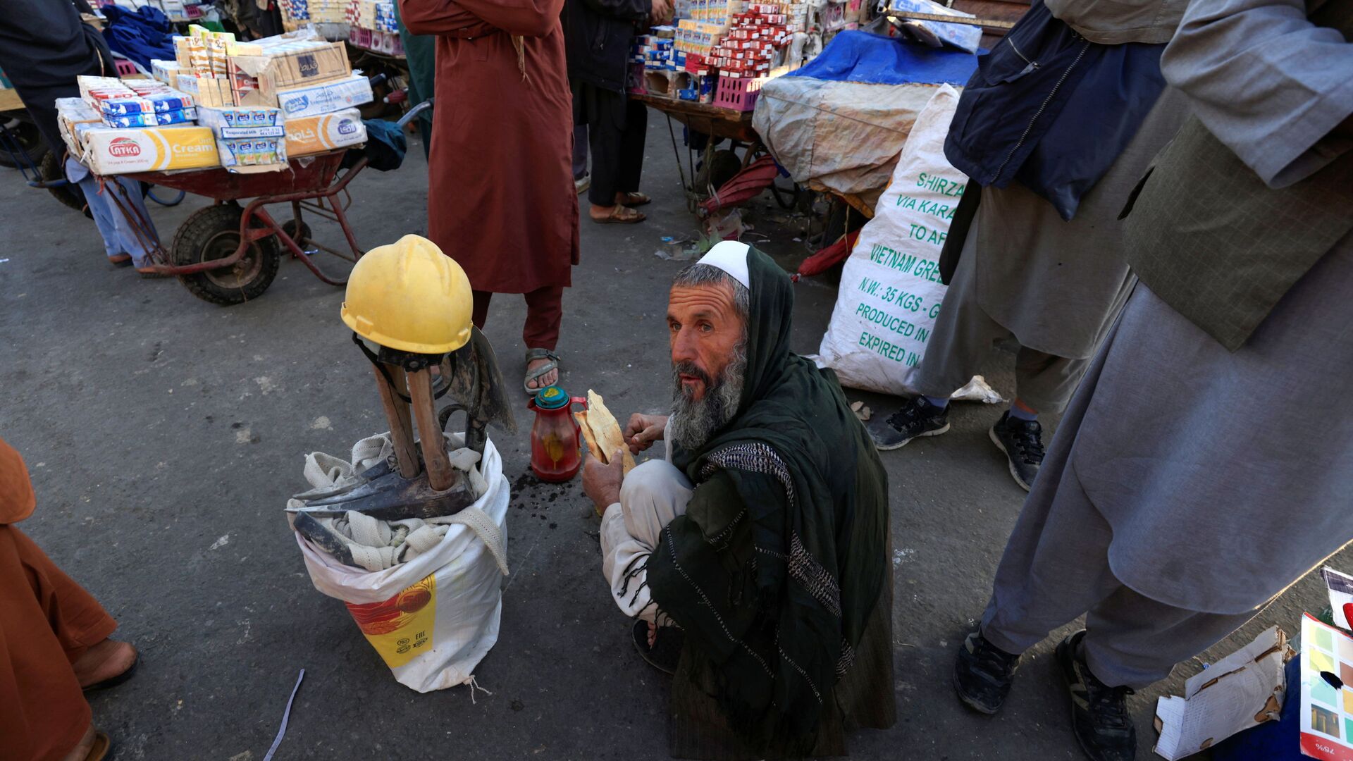 55-летний Гул Мохаммад завтракает, сидя рядом со своими инструментами в ожидании работы на рынке в Кабуле, Афганистан - Sputnik Тоҷикистон, 1920, 12.12.2021