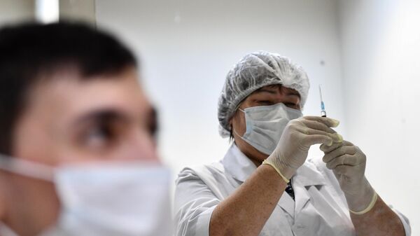 Мужчина делает прививку в пункте вакцинации от коронавируса Covid-19 - Sputnik Тоҷикистон