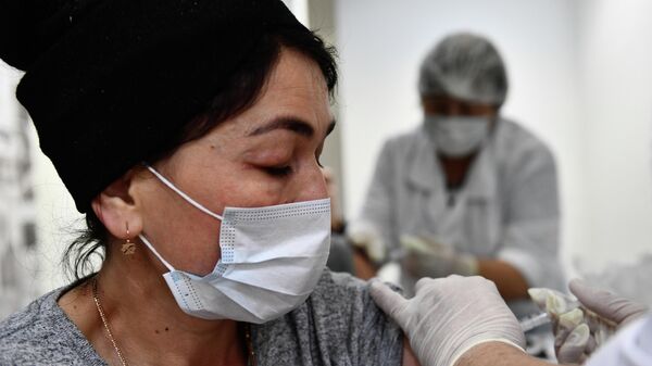 Женщина делает прививку в пункте вакцинации от коронавируса Covid-19  - Sputnik Таджикистан