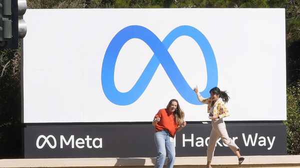 Сотрудники Facebook на фоне нового логотипа компании у ее штаб-квартиры в Менло-Парке, Калифорния - Sputnik Таджикистан