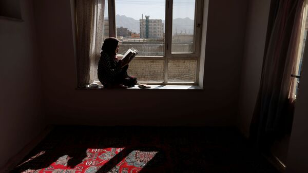 20-летняя студентка Хава читает книгу на подоконнике своего дома в Кабуле, Афганистан - Sputnik Таджикистан