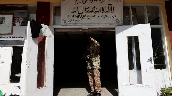 Боевик Талибана* у входа в школу в Кабуле, Афганистан - Sputnik Тоҷикистон