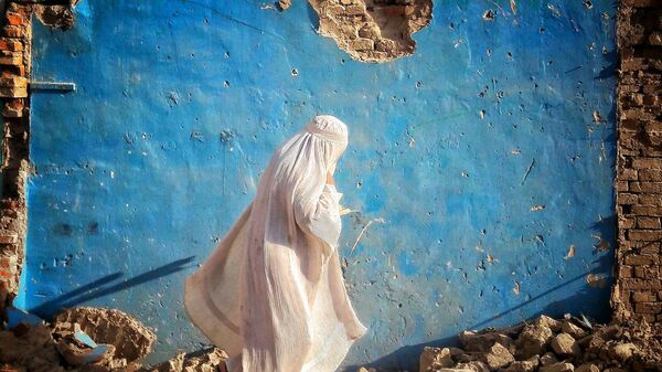 Девушка в белой бурке у разрушенного дома в Афганистане  - Sputnik Тоҷикистон
