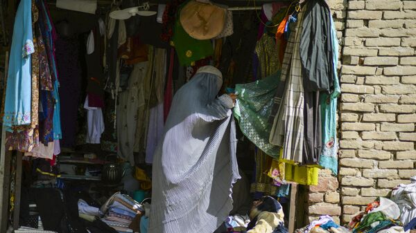Женщина в бурке в магазине одежды в Кандагаре  - Sputnik Тоҷикистон