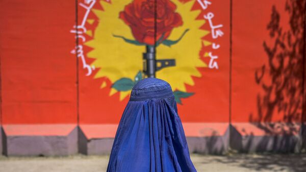 Женщина в бурке напротив граффити в Кабуле  - Sputnik Тоҷикистон