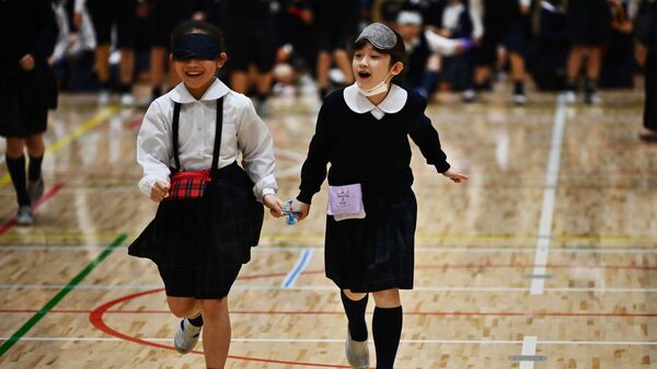 Ученики начальной школы Ariake-nishi Gakuen принимают участие в упражнения под руководством параатлета Чиаки Такада, приуроченных к Паралимпийским играм 2020 года в Токио в Токио - Sputnik Тоҷикистон