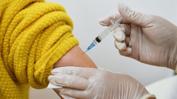 Медицинский работник делает прививку от коронавируса - Sputnik Тоҷикистон