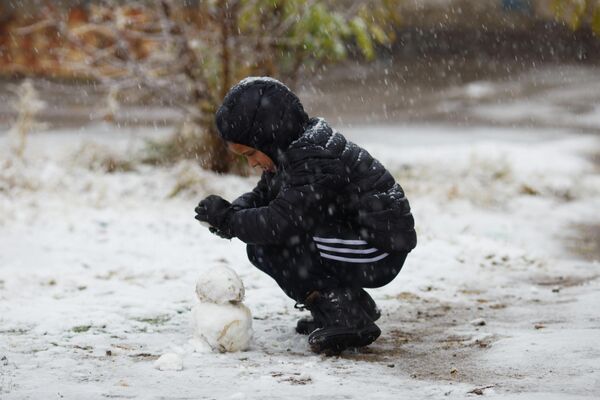 дети ловят момент и лепят снеговиков, пока не растаяло. - Sputnik Таджикистан