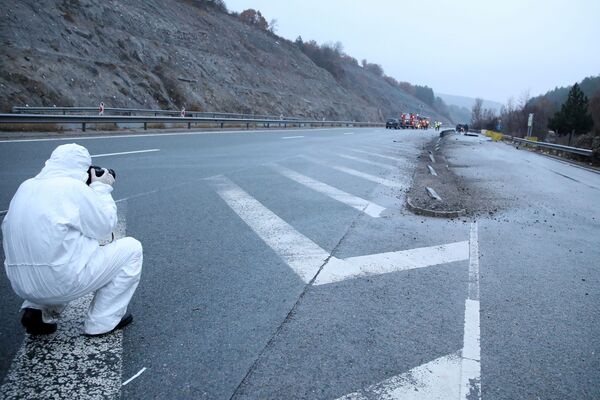 Сотрудник судебно-медицинской полиции осматривает место, где на шоссе загорелся автобус с северно-македонскими номерами, недалеко от деревни Боснек. - Sputnik Таджикистан