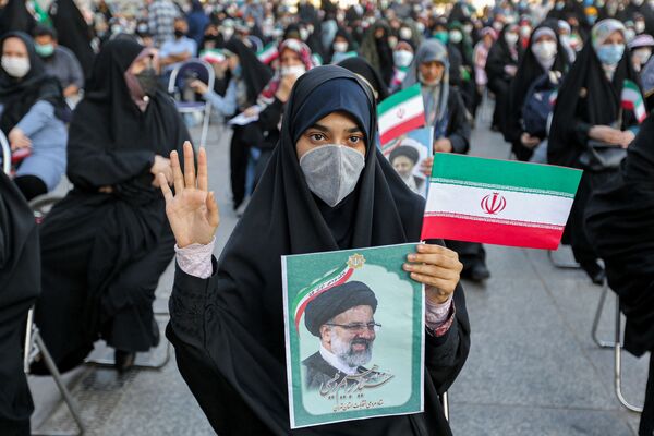 Женщина держит фотографию новоизбранного президента Ирана Ибрахима Раиси, 19 июня. - Sputnik Таджикистан