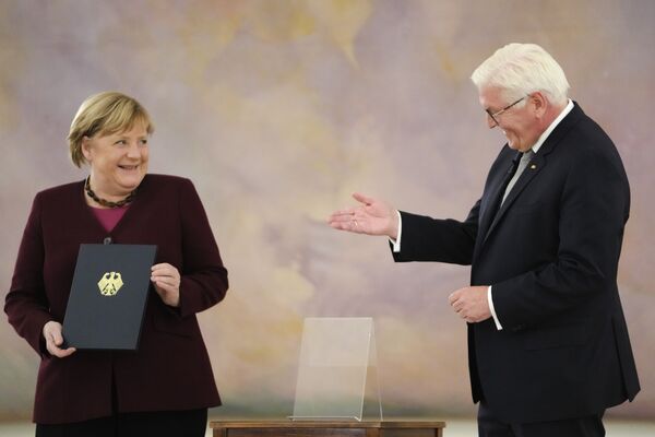 Канцлер Германии Ангела Меркель получает свидетельство об увольнении от президента ФРГ Франка-Вальтера Штайнмайера в Берлине, 26 октября. - Sputnik Таджикистан
