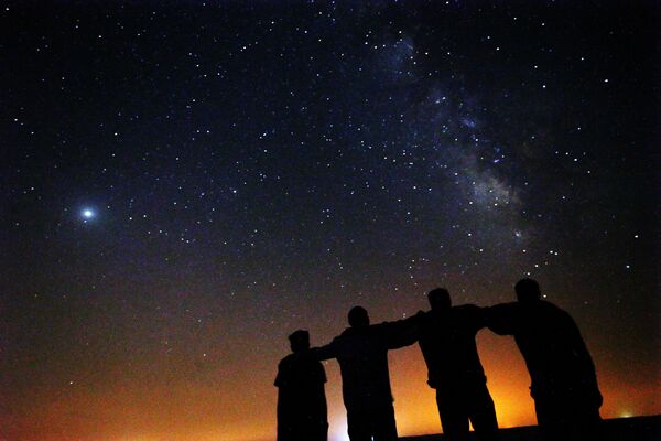 Друзья рассматривают Млечный Путь, восходящий в ночном небе пустыни Кувейта в 120 км к северу от столицы. - Sputnik Таджикистан