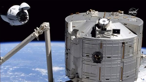 Изображение космического корабля SpaceX Crew Dragon приближается к международной космической станции. - Sputnik Таджикистан