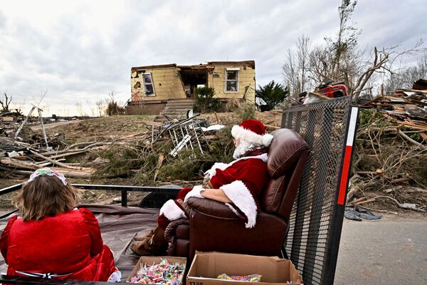 Жители города Доусон Спрингс в штате США Кентукки празднуют Рождество в обломках дома, разрушенного сильнейшим торнадо. - Sputnik Таджикистан