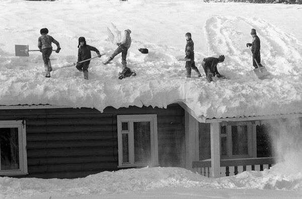 Снежная зима в Коми АССР. Мальчики чистят снег на крыше дома в Сыктывкаре, 1988-й. - Sputnik Таджикистан