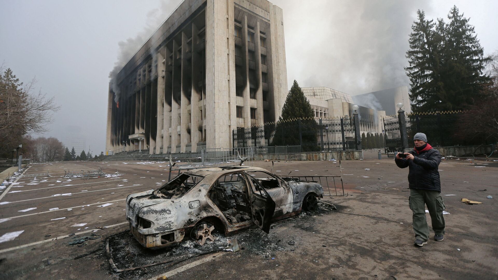 Сгоревший автомобиль перед зданием мэрии, которое было подожжено во время протестов в Алматы - Sputnik Таджикистан, 1920, 10.01.2022