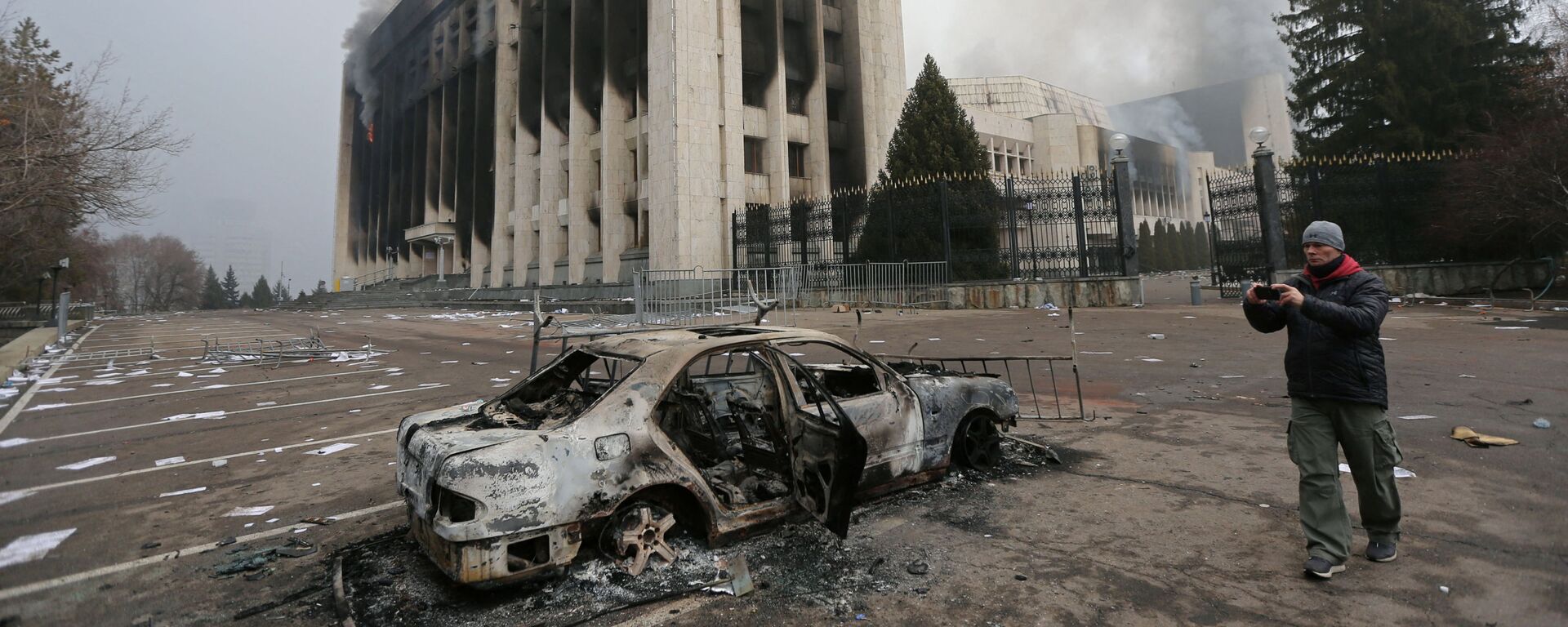 Сгоревший автомобиль перед зданием мэрии, которое было подожжено во время протестов в Алматы - Sputnik Таджикистан, 1920, 08.01.2022
