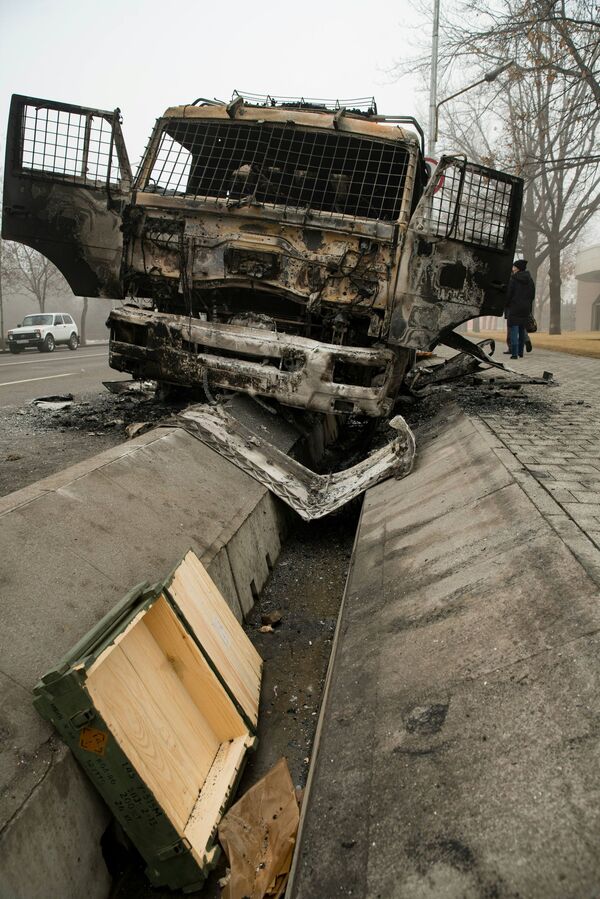 Сожженный грузовик правоохранительных органов в центре Алматы -   последствия массовых погромов. - Sputnik Таджикистан