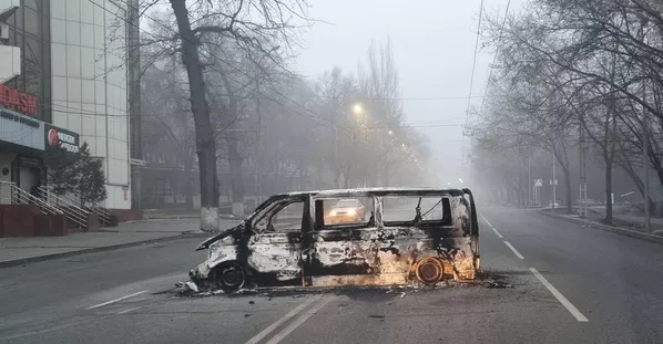 Мошин дар яке аз ҷодаҳои Алмаато пас аз гирдиҳамоӣ ба коми оташ рафт. Мошин дар яке аз ҷодаҳои Алмаато пас аз гирдиҳамоӣ ба коми оташ рафт. - Sputnik Тоҷикистон